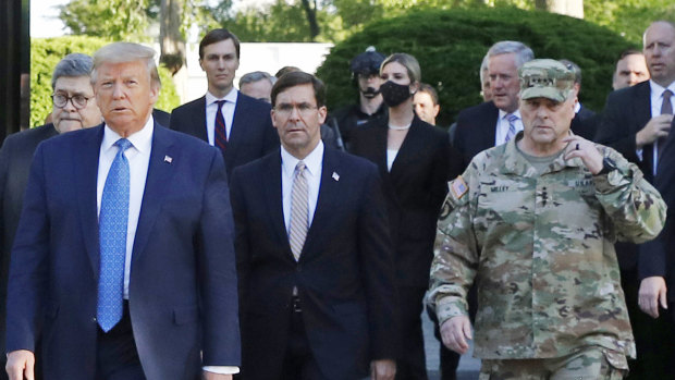 Trump's controversial use of troops to clear protesters in June. Trump postures with Chair of the Joint Chiefs of Staff, General Mark Milley, then-secretary of defence Mark Esper is in the middle.