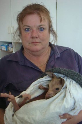 Janine Green holding the sole survivor from a night of senseless slaughter.