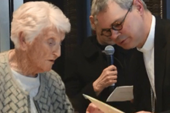 Eileen Piper, 93, shows Catholic archbishop Peter Comensoli a picture of her daughter at his Melbourne Press Club appearance.