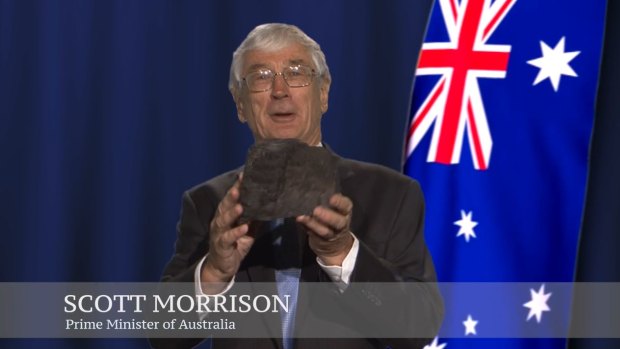 A screen grab of Dick Smith talking about renewable energy, holding a piece of coal and pretending to be Prime Minister Scott Morrison.