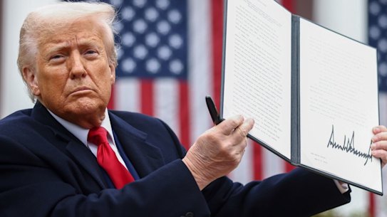 US President Donald Trump displays the signed executive order after his tariff announcement.