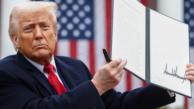 US President Donald Trump displays the signed executive order after his tariff announcement.