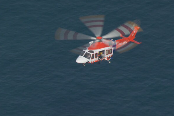 An ambulance helicopter near where the three people were washed into the water on Friday.
