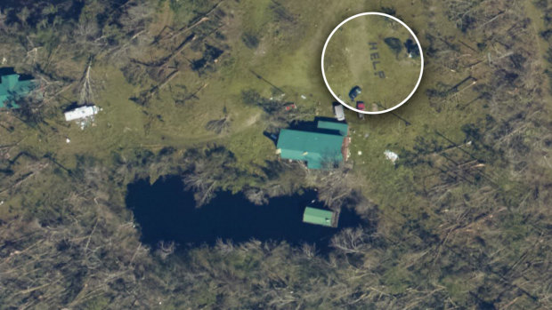 NOAA National Geodetic Survey damage assessment imagery showing a home near Youngstown, Florida where the word "HELP" has been spelled out with logs.