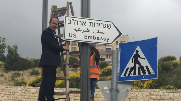 Jerusalem Mayor Nir Barkat poses with a new road sign to the US embassy in Jerusalem.