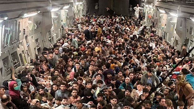 Afghan citizens pack inside a U.S. Air Force C-17 Globemaster III, as they are transported from Hamid Karzai International Airport in Afghanistan, on Aug. 15, 2021.