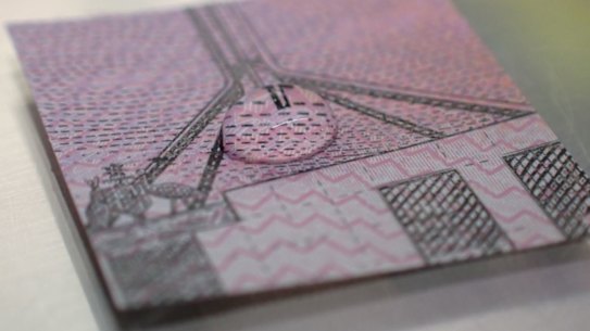 A droplet of the COVID-19 virus in artificial mucous on a small section of the $5 note.