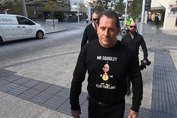 Troy Mercanti sporting a message for  Attorney General John Quigley on his way to a previous court appearance.