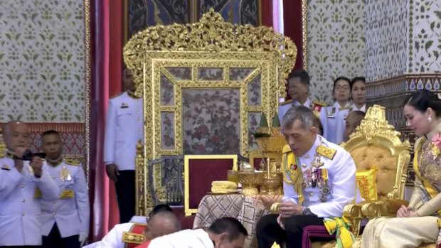 In this image made from video, Thailand’s King Maha Vajiralongkorn, centre, and Queen Suthida, right, are greeted by Thai Prime Minister Prayuth Chan-ocha, bottom front, during the second of a three-day coronation ceremony.