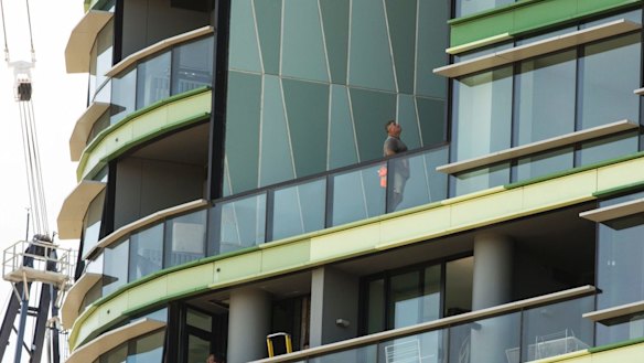 Tradesmen work on Opal Tower in Olympic Park.