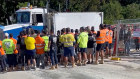 A crowd of about 30 to 40 men in CFMEU-branded clothing at the Centenary Bridge Upgrade site on May 14.