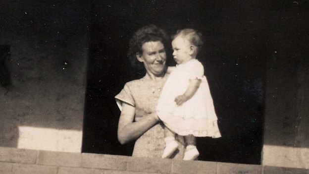 The author’s mother, holding toddler Christine, at their completed home. 