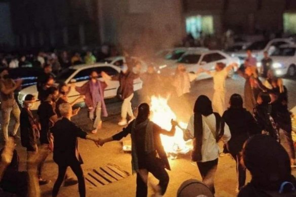 Women burn their headscarfs together in protest against Mahsa Amini’s death. 