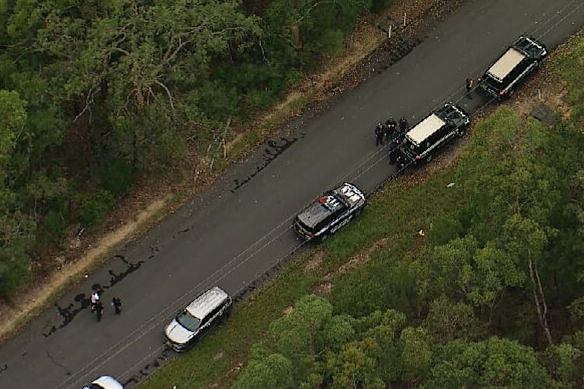 Several vehicles have congregated near dense bushland in Glenorie.
