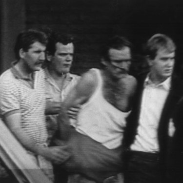 Cox (in singlet) during his arrest in 1988.