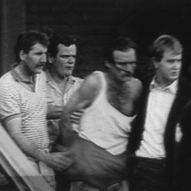 Cox (in singlet) during his arrest in 1988.