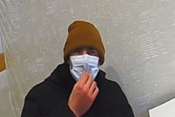 A polícia pede a Luigi Mangione que baixe a máscara.