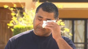 Queensland rugby legend Toutai Kefu wipes away his tears as he addresses media outside his home after a violent break-in.
