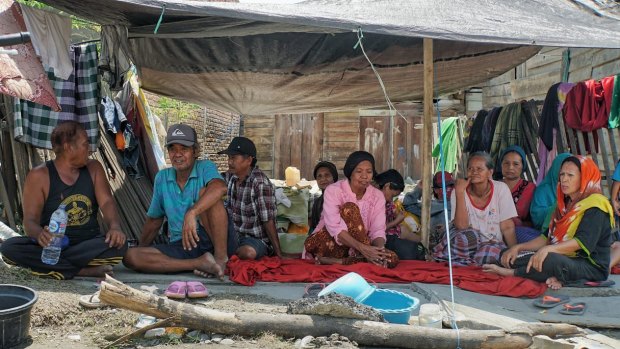 Sangati, far right, and neighbours sit under a tarpaulin that will serves as shelter also at night.