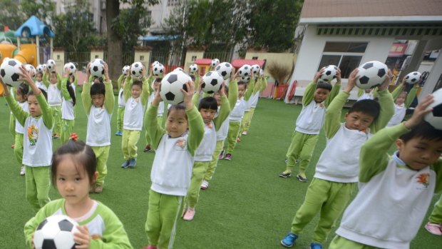 Kindergarten children do choreographed football exercises to teach them football culture at Yangzhou University Kindergarten, Jiangsu, China, in 2016.