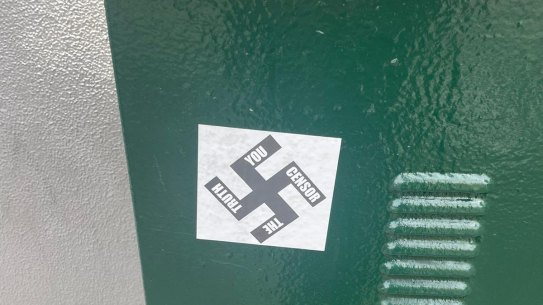 Two men have been charged after allegedly plastering Nazi swastika stickers on buildings in Caulfield.