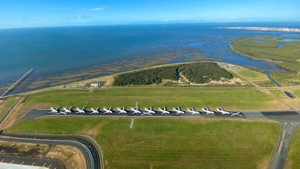 Grounded Virgin Australia planes lined up on Brisbane Airport's decommissioned cross runway.