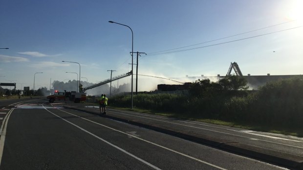 Firefighters work to extinguish a fire at Lytton Road near the Port of Brisbane which forced the road to close.