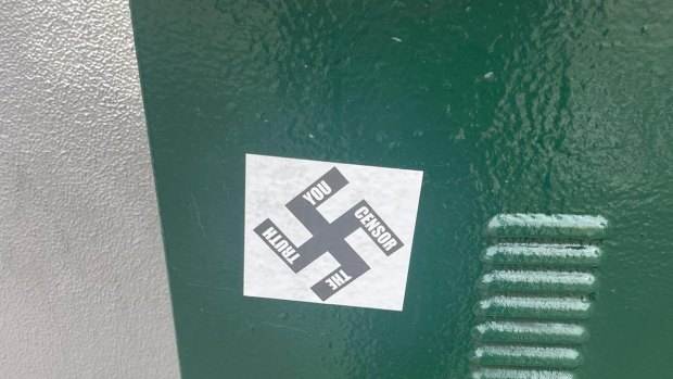 Two men have been charged after allegedly plastering Nazi swastika stickers on buildings in Caulfield.