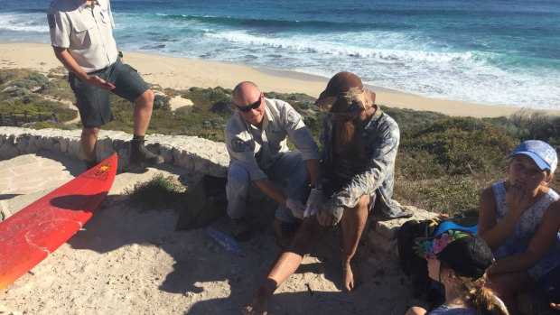 Jason Longgrass, 41, is treated by paramedics after he was bitten on his right leg at Lefties, the second shark attack in Gracetown this week.