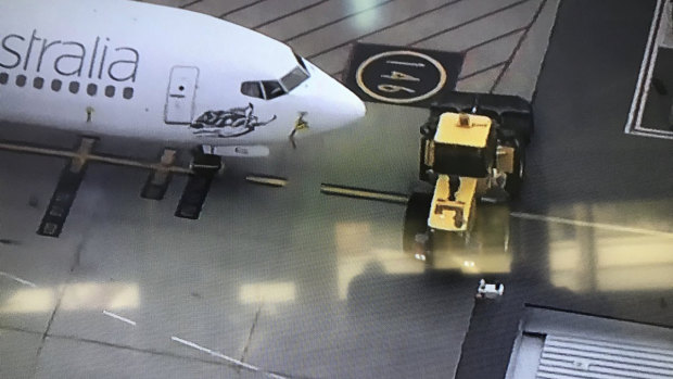 A bulldozer blocks access for vehicles wanting to pushback this plane at Perth Airport.