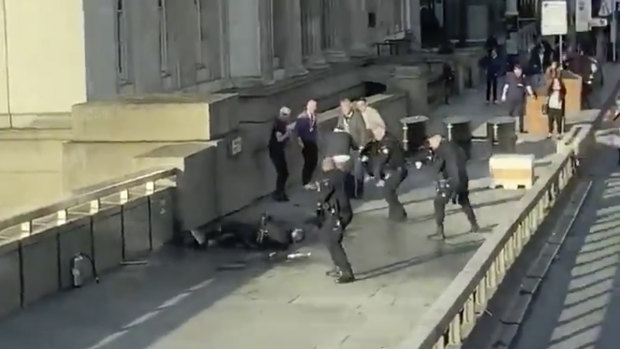 In this grab taken from video,, a man is surrounded by police after an incident on London Bridge.