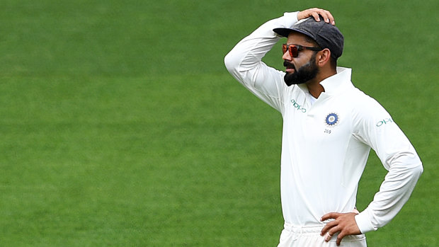 Complication: Virat Kohli reacts as the Australian tail wags a little too vigorously for his liking.