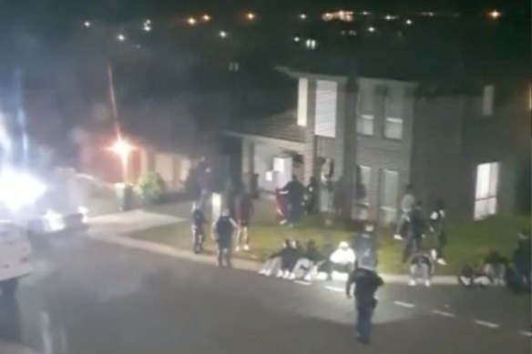 A screenshot of a neighbour's video footage shows police rounding up rowdy partygoers.