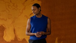 Designer Brahman Perera in front of his Temple Silhouette carpet for Ruggable.