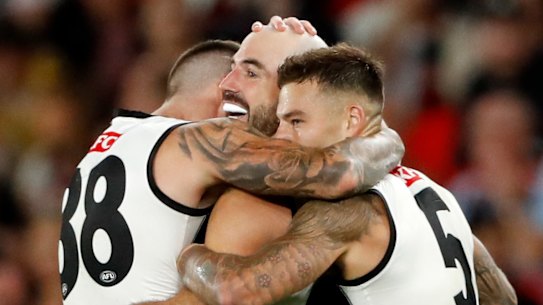 Collingwood players celebrate a goal.