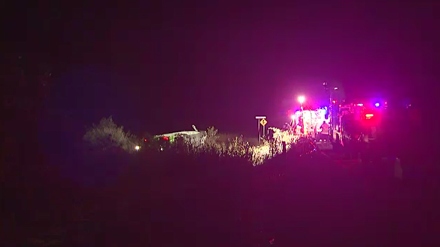 One person is dead and at least two others are fighting for life after a bus rollover in north Queensland injured about 20 people.