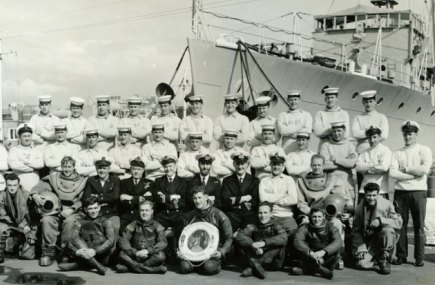 With his navy colleagues. Fitzgerald wears white a jumper and sits in the second row next to a diver.