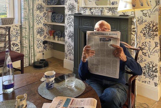 Rupert Murdoch captured in his element: reading one of his many newspapers at home.