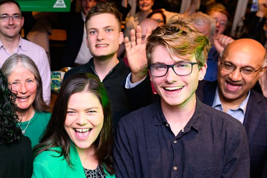 Benjamin Chesler behind Greens candidates Nick Savage (Hawthorn) and Jackie Carter (Kew) at a campaign launch last month.