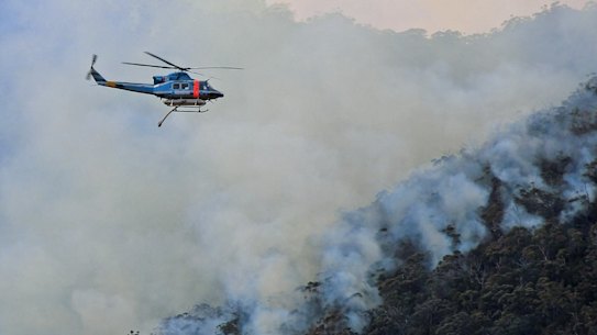 A helicopter waterbombing fires on the NSW South Coast.