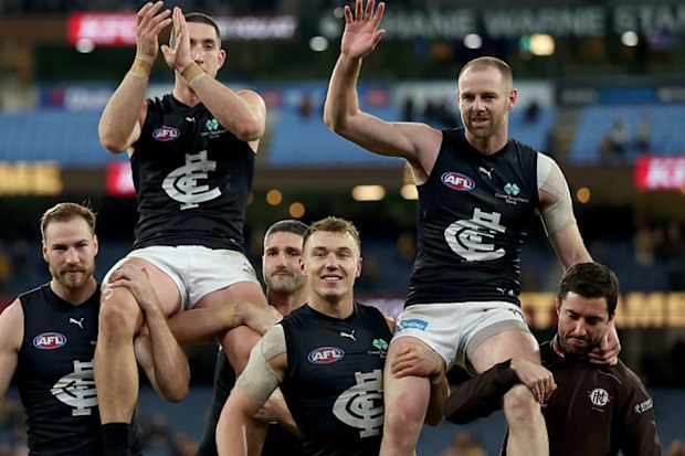 Jacob Weitering is chaired off the ground following his 200th game and Sam Docherty following his final game.
