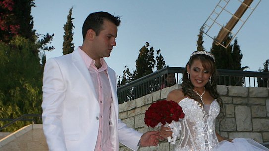 An Israeli bride and groom pose for a photographer prior to their wedding