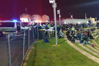 Ambulance officers provide first aid to Nick Martin and Ricky Chapman after the Perth Motorplex shooting.