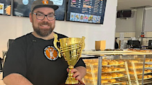 Mitchell holding their gourmet sausage roll trophy.