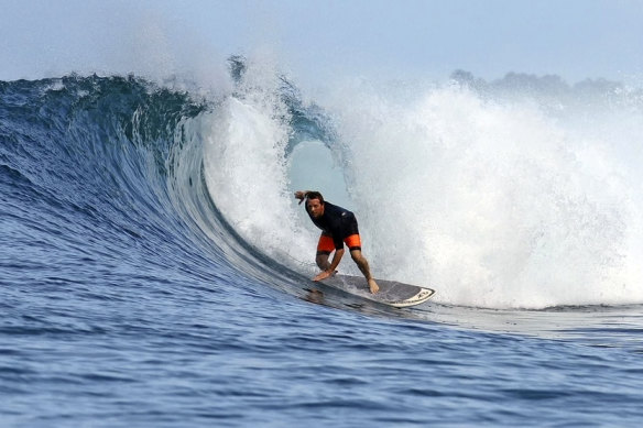 Surfer Brett Ryan rides a wave.