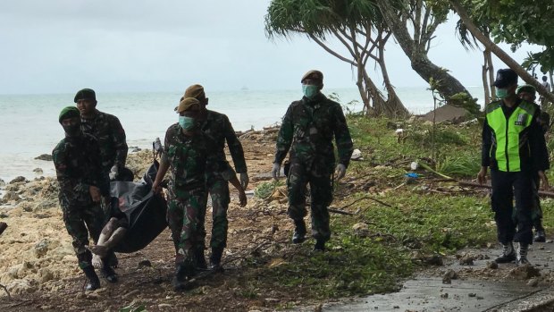 Indonesian officials find a body on the beach at Tanjung Lesung, one of the hardest hit villages.