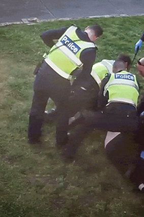An image from CCTV showing police restraining John outside his Preston home in 2017.