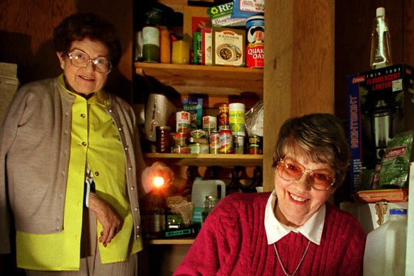 Two women show off their disaster supplies as they prepare for the end of the world in <i>Time Bomb Y2K</i>.