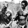 Private George “Dick” Whittington is guided from the Battle of Buna byb”Fuzzy Wuzzy Angel” Raphael Oimbari. Christmas Day, 1942.