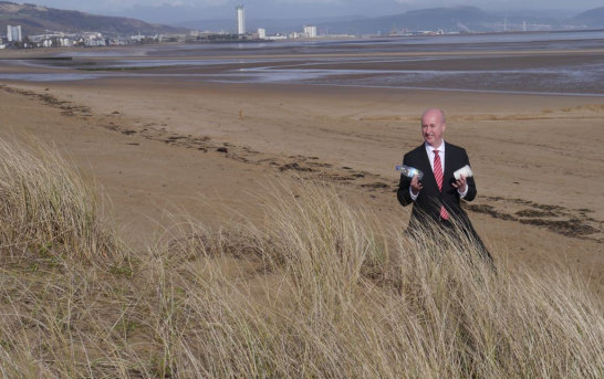 British Labour MP Geraint Davies collects plastic rubbish washed up on Swansea Beach in Wales.